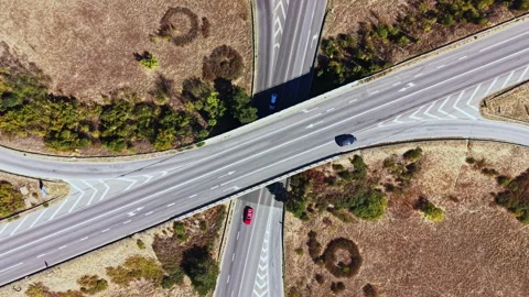 Highway intersection with vehicles and green areas in a rural landscape during Stock Footage 347750816