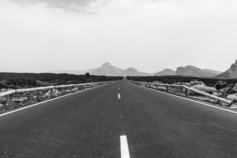 Highway leading to the mountains. Black and white. Stock Photos