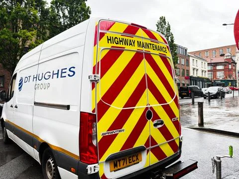 Highway maintenance van with high visibility chevrons parked on a wet stree.. Stock Photos