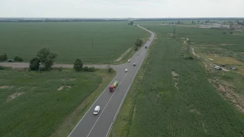 A highway in the middle of a green field on which trucks and cars travel Stock Footage 246717105