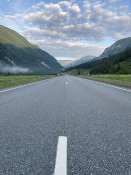 Highway in mountains under cloudy sky, Russia, Siberia, Altai mountains Stock Photos