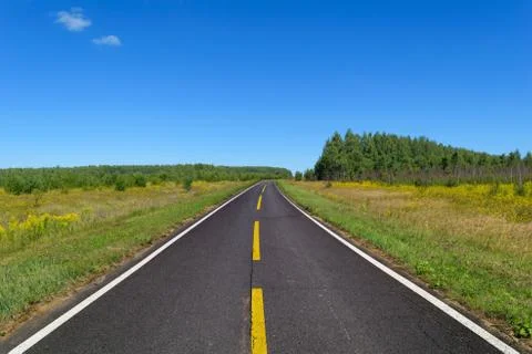 Highway with one line of dashed yellow and two line of solid white road markings Stock Photos
