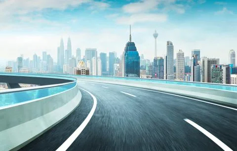 Highway overpass motion blur effect with modern city skyline background . Day Stock Photos