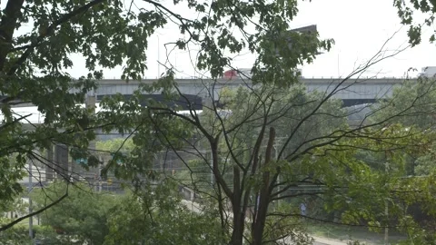 Highway overpass through trees, green leaves, wind 库存影片 304367345