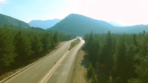 A Highway Passes the Forest Through the Mountains Drone Shot Stock Footage 146177876
