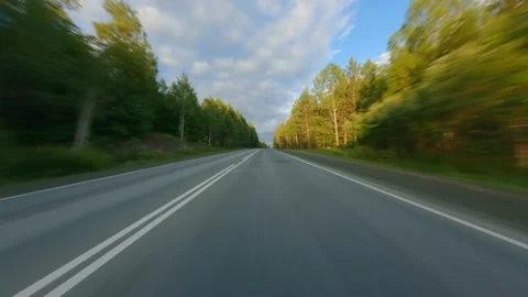 The highway passes through a dense forest. The crowns of tall trees are Stock Footage 157997898