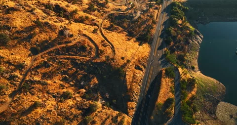 Highway passing between the mountains and a lake.  Stock Footage 250429024