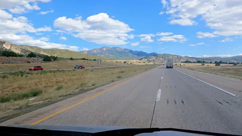 Highway road trip view with a semi-truck ahead and beautiful mountains under -27 Stock-Footage 346102901