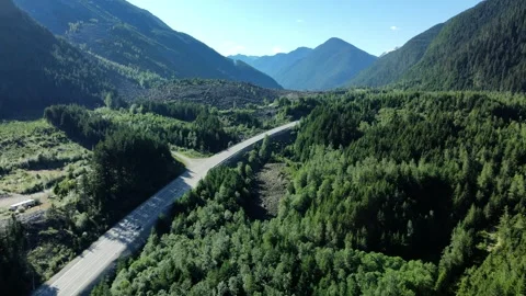 Highway through a Green Forest Valley with Mountains, Aerial Drone View Stock Footage 289486127