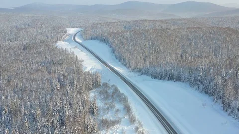 Highway through the winter forest, aerial photography from UAVs. Snow-covered 動画素材 123711801