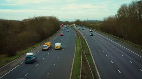 Highway traffic flowing along multi lane motorway with cars and trucks moving in Stock Footage 329771613
