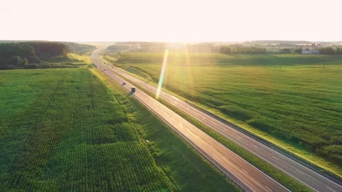 Highway traffic at sunset through green fields Stock-Footage 302203616