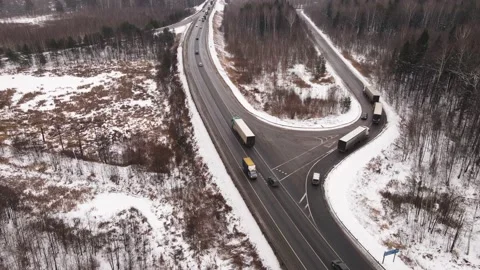 Highway with trucks turning onto a parallel road in winter, aerial view Stock Footage 161324903