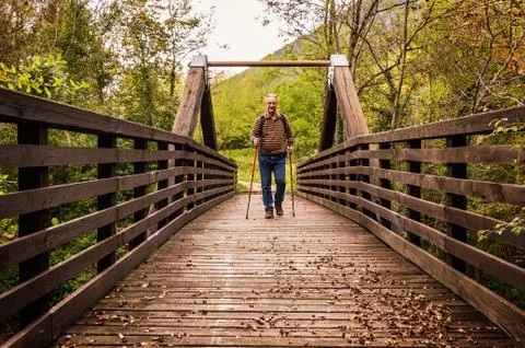 Hike man with backpack walking in forest nature outdors bridge. Stock-Fotos