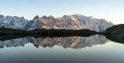 Hiker admiring Dent du Geant and Mont Blanc covered with snow reflected in Lacs Stock Photos