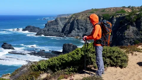 Hiker Admiring Dramatic Cliffside Scenery on Portugals Fishermens Trail Stock Footage 319317756