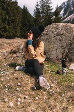 Hiker applying sunscreen while resting in a meadow of crocuses Stock Photos