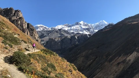 Hiker with backpack at Annapurna hike along steep mountains Stock Footage