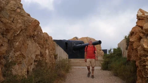 A hiker with a backpack comes from an old cannon in the fortress. Stock Footage 138207638