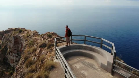 The hiker with a backpack enjoys the view from Cabo Tinoso. Stock Footage 138207961