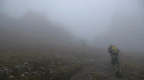 Hiker with backpack in the mountains fog Stock Footage 63028633