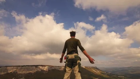 Hiker with backpack relaxing on top of a mountain and enjoying sunrise Stock Footage 69189580