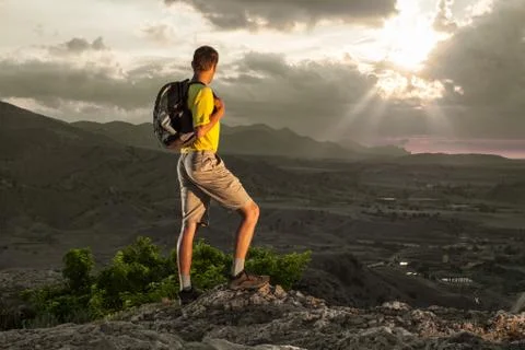 Hiker with backpack standing on a rock Foto stock