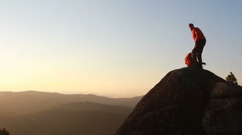 Hiker with backpack standing on top of a mountain Video stock 29664688