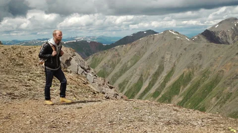 Hiker with backpack standing on top of a mountain Stock Footage 65311461