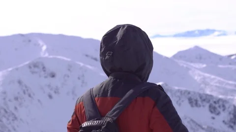 Hiker with backpack standing on top of a mountain and enjoying Stock Footage 73753746