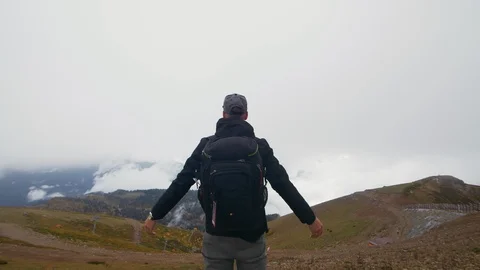 Hiker with backpack standing on top of a mountain Stock Footage 97433812