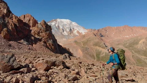 Hiker with a backpack stands on a large stone in the mountains Stockbeeldmateriaal 122266465