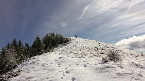 Hiker With Backpack Walking On A Mountain Ridge, Covered With Deep Snow Stock Footage 126116532