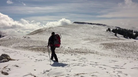 Hiker With Backpack Walking On A Mountain Ridge, Covered With Deep Snow Stock Footage 126117802