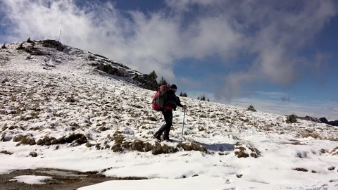 Hiker With Backpack Walking On A Mountain Ridge, Covered With Deep Snow Stockbeeldmateriaal 126117805