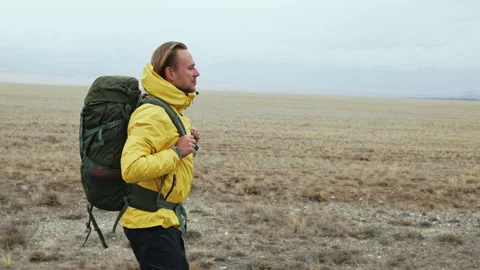 Hiker with backpack walking through steppe in autumn Stock Footage 231480113
