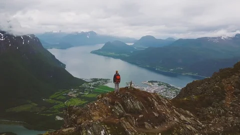 Hiker backpacker standing on top of mountain, drone turning around Stock Footage 93904689