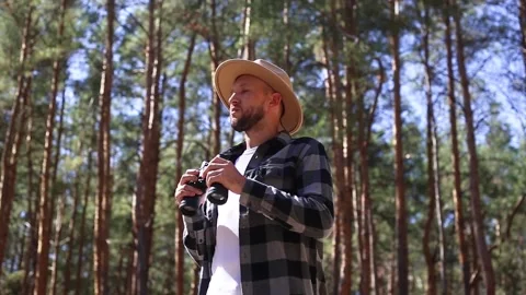 Hiker with binoculars looks around while walking into the forest. Stock Footage 149945678