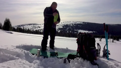 Hiker breaking down camp in the winter mountains Stock Footage 172111380