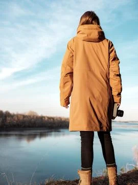 Hiker with camera admiring view while standing against river Stock Photos