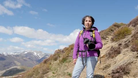 Hiker with camera and backpack taking picture of beautiful mountain Stock Photos