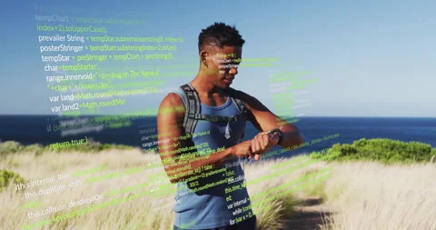 Hiker checking smartwatch on coastal dune path, featuring wearable tech code 库存影片 308184645