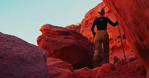 Hiker Climbing Red Rock Formation in Desert Landscape Stock Footage 323799658