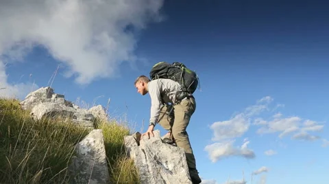 Hiker climbing rocks to look at view Stock Footage 45500064