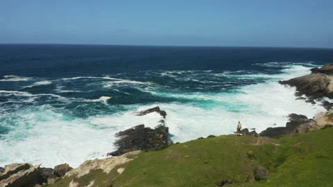 Hiker close to big waves crashing in Jaizkibel, in Basque Country, Spain Video stock 154700341
