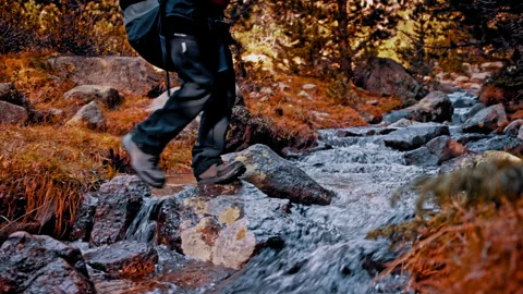 Hiker crossing a stream in the Pyrenees mountains of Spain Stock Footage 303632004
