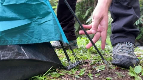 Hiker Disassembling Tent Pole in Forest Campsite, Close-Up Shot Video stock 323585894