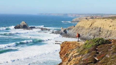 Hiker on dramatic coastal cliff overlooking the Atlantic Portugal Stock Footage 319670742