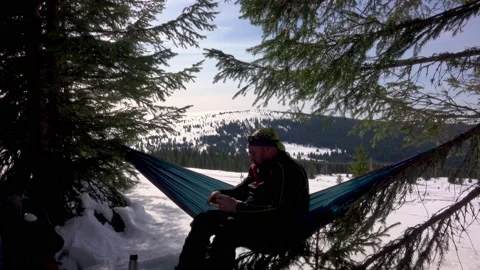 Hiker Drinking Cofee And Reading A Book, Lying In Hammock In Winter Forest Stock Footage 172111405