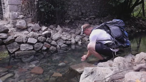 Hiker drinking from a stream, hiking Stock Footage 201966203